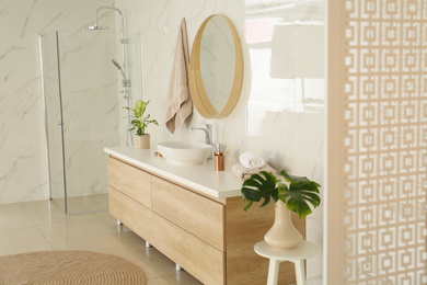 Round mirror over vessel sink in stylish bathroom interior