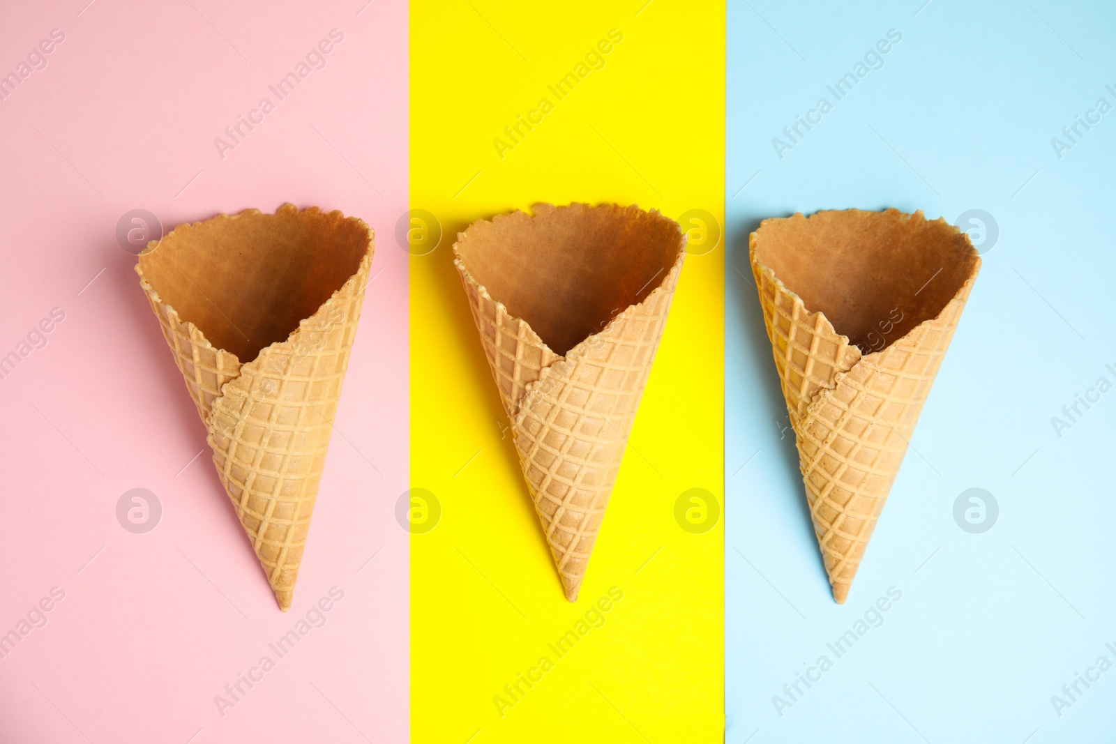 Photo of Empty wafer ice cream cones on color background, flat lay