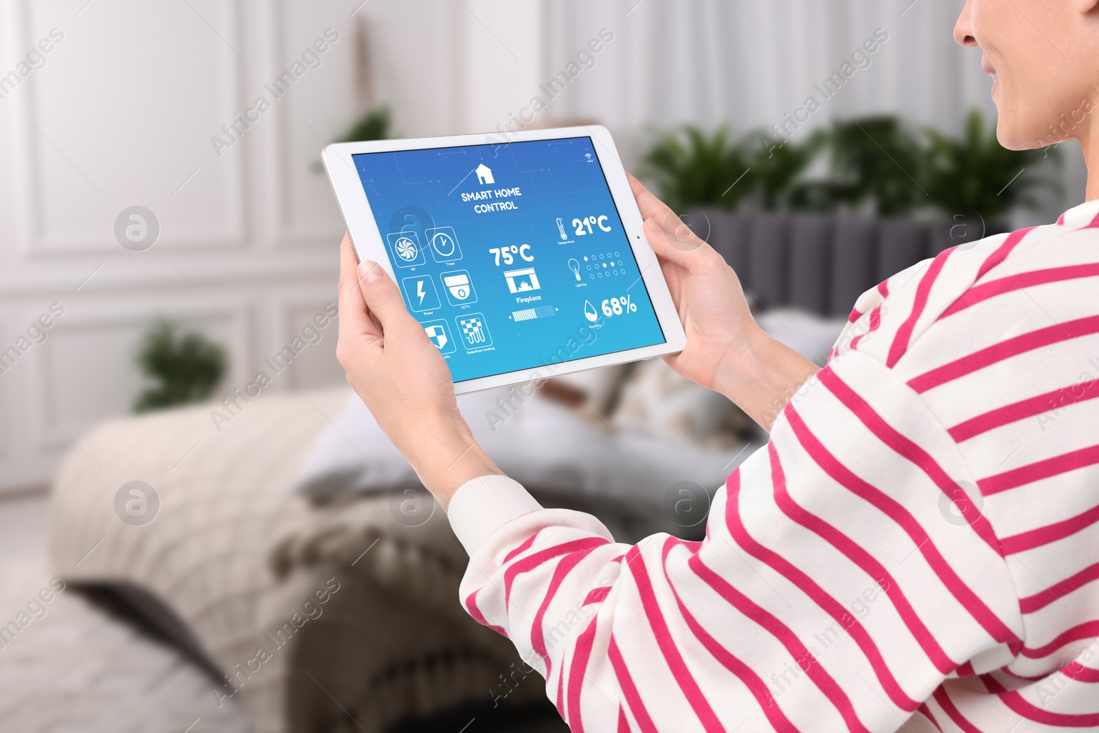 Image of Woman using smart home control system via application on tablet indoors, closeup