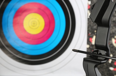 Photo of Bow with arrow aiming archery target, closeup