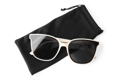 Stylish sunglasses with black cloth bag on white background, top view