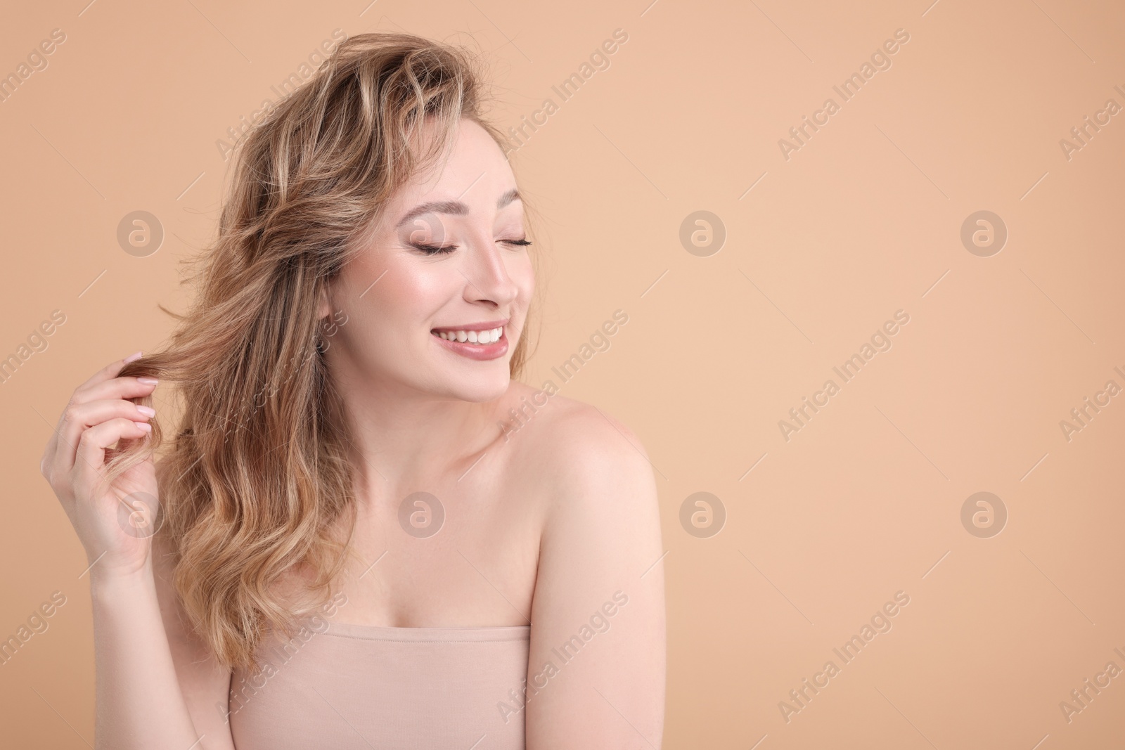 Photo of Portrait of smiling woman on beige background. Space for text