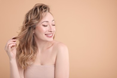 Portrait of smiling woman on beige background. Space for text