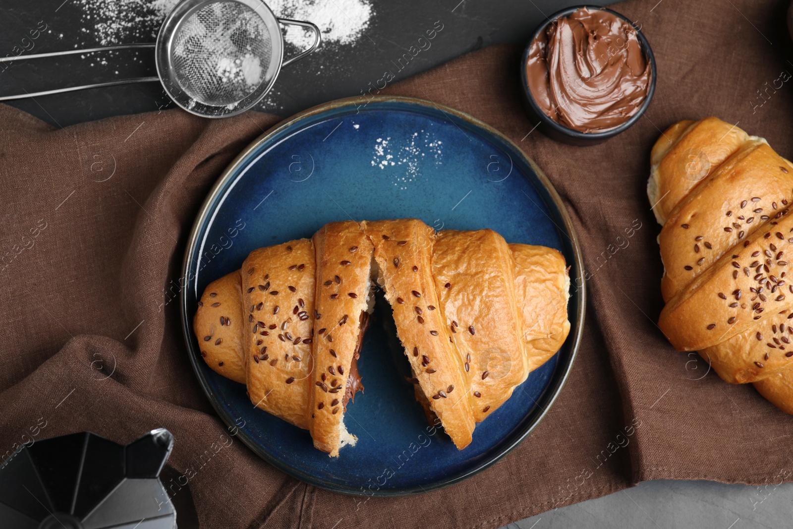 Photo of Flat lay composition with tasty croissants, sugar powder and chocolate paste on table