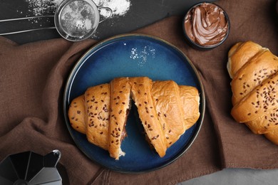 Photo of Flat lay composition with tasty croissants, sugar powder and chocolate paste on table