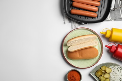 Photo of Different tasty ingredients for hot dog on white table, flat lay. Space for text