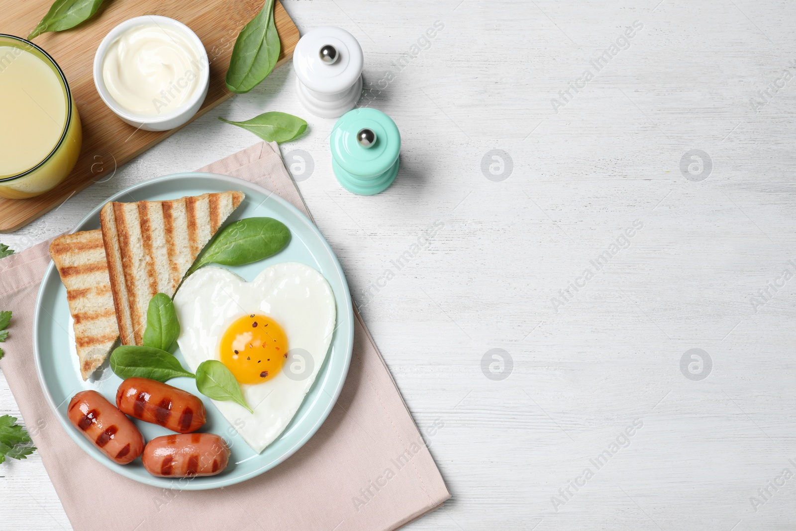 Photo of Tasty breakfast with heart shaped fried egg served on white wooden table, flat lay. Space for text