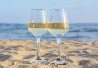 Photo of Glassestasty wine on sand near sea
