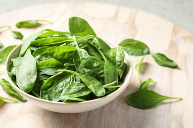 Photo of Bowl of fresh green healthy spinach on table