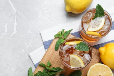 Photo of Delicious iced tea on light grey marble table, flat lay. Space for text