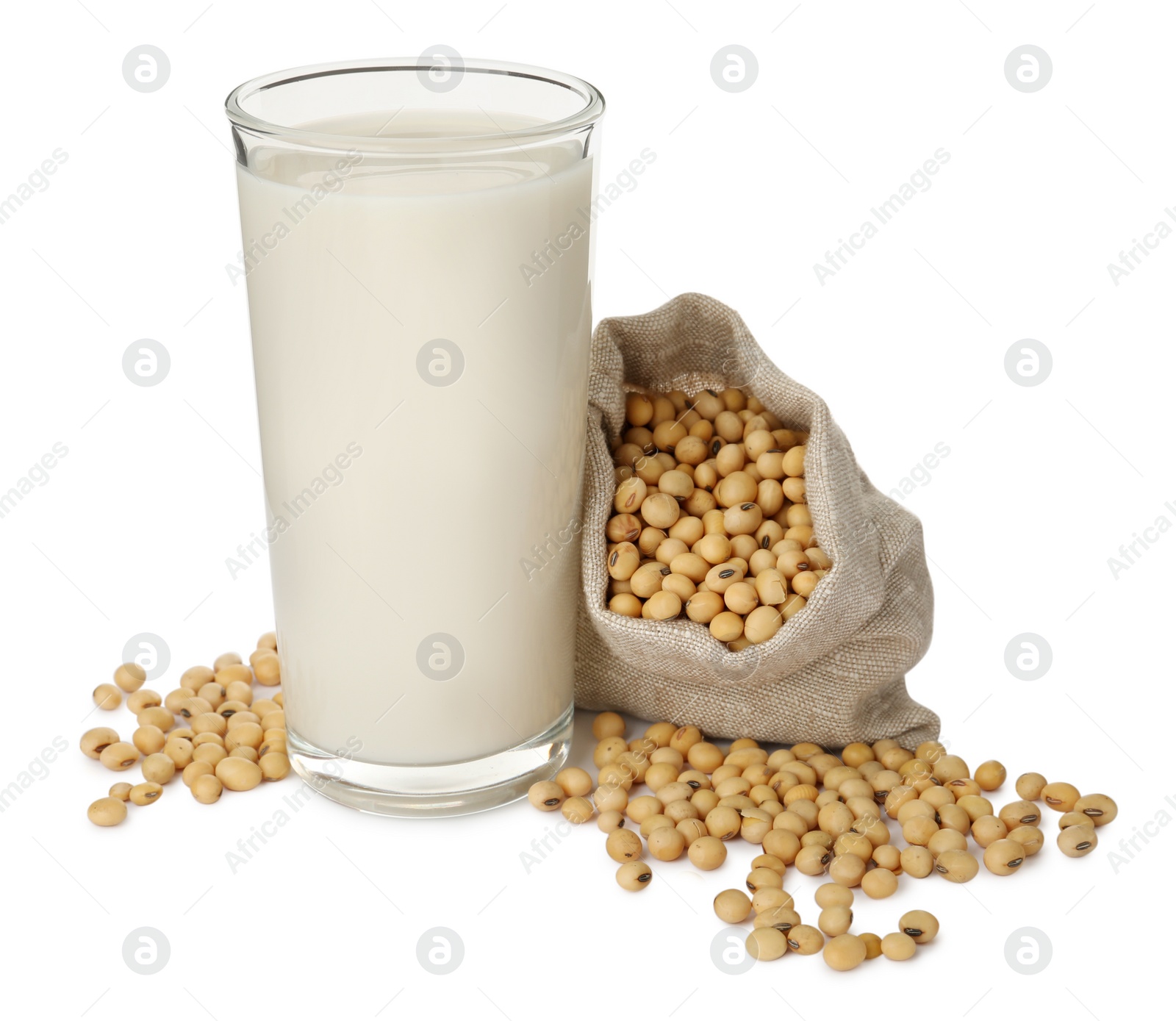 Photo of Glass of fresh soy milk and sack bag with beans on white background