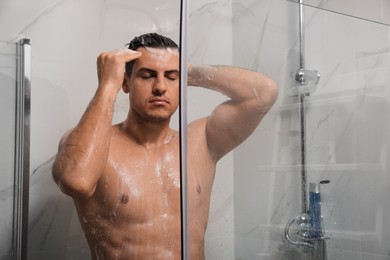 Man taking shower with gel at home