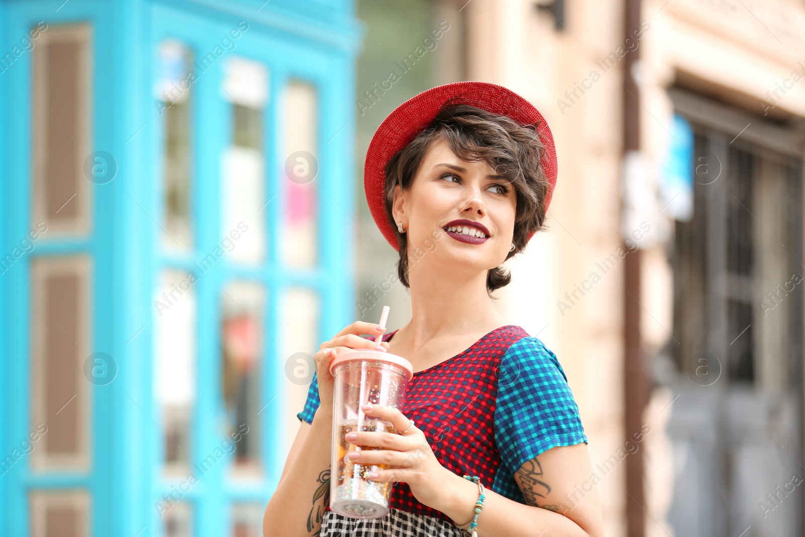 Photo of Young woman with cup of tasty lemonade outdoors