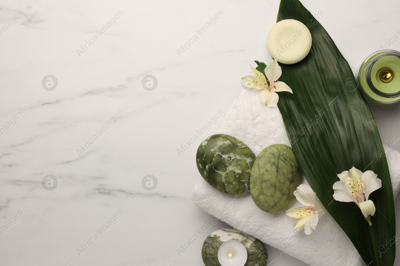 Photo of Flat lay composition with spa products and flowers on white marble table. Space for text