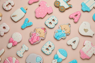 Photo of Set of baby shower cookies on light pink background, flat lay