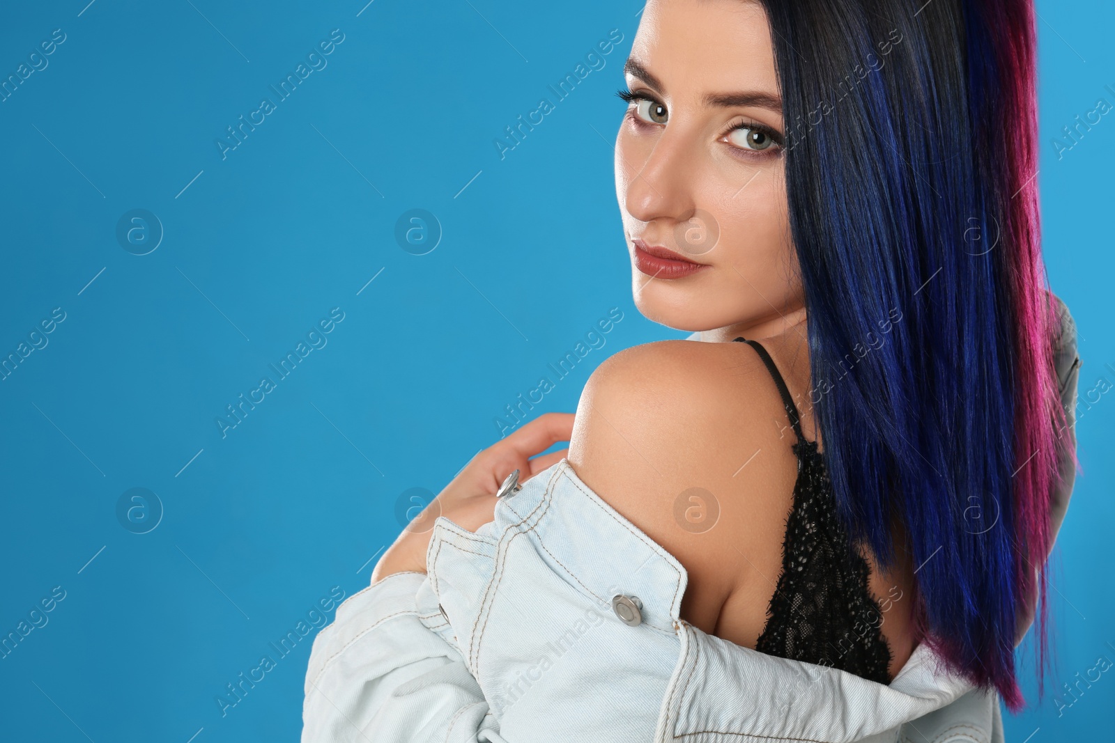 Photo of Young woman with bright dyed hair on blue background