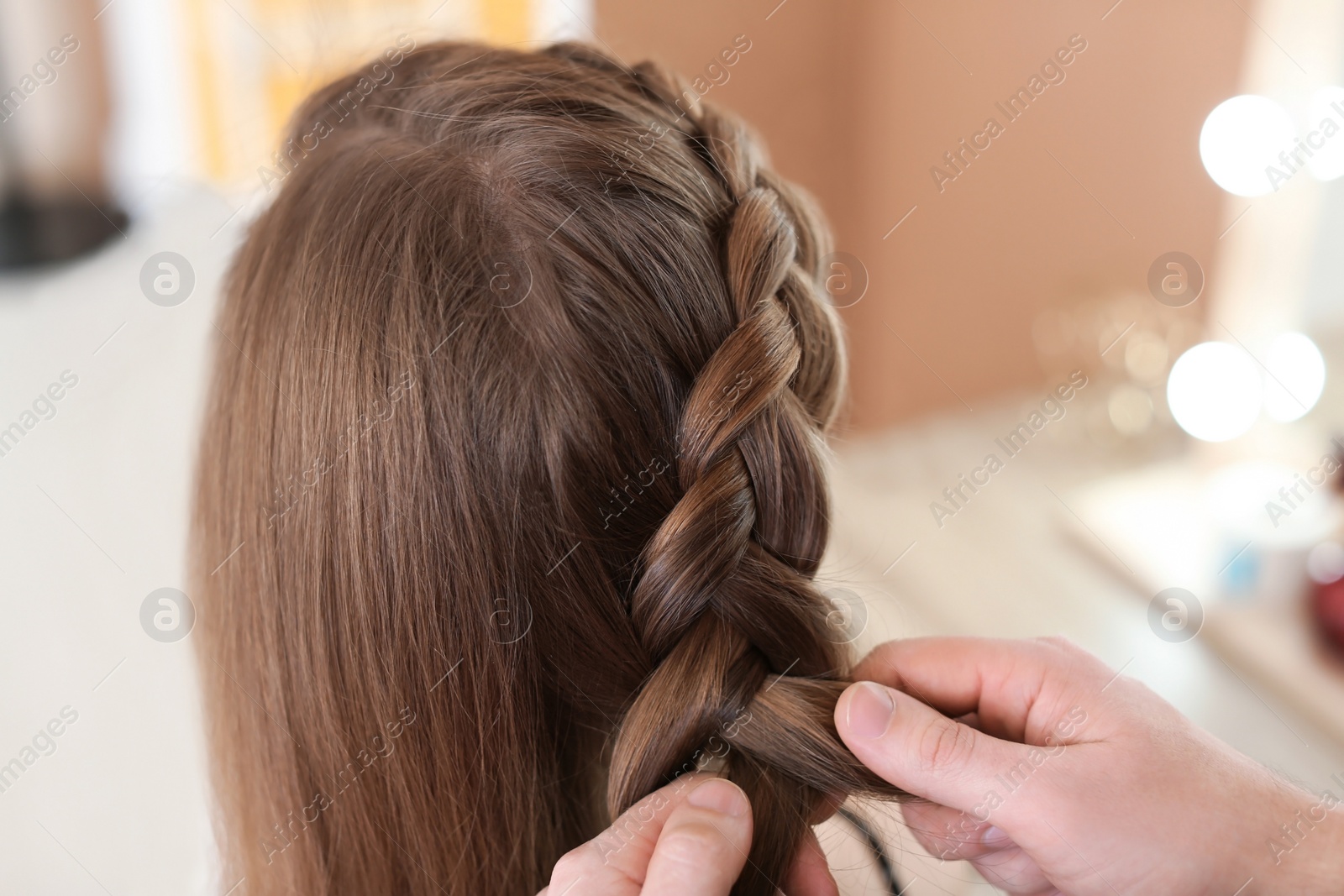 Photo of Professional hairdresser working with client in beauty salon, closeup