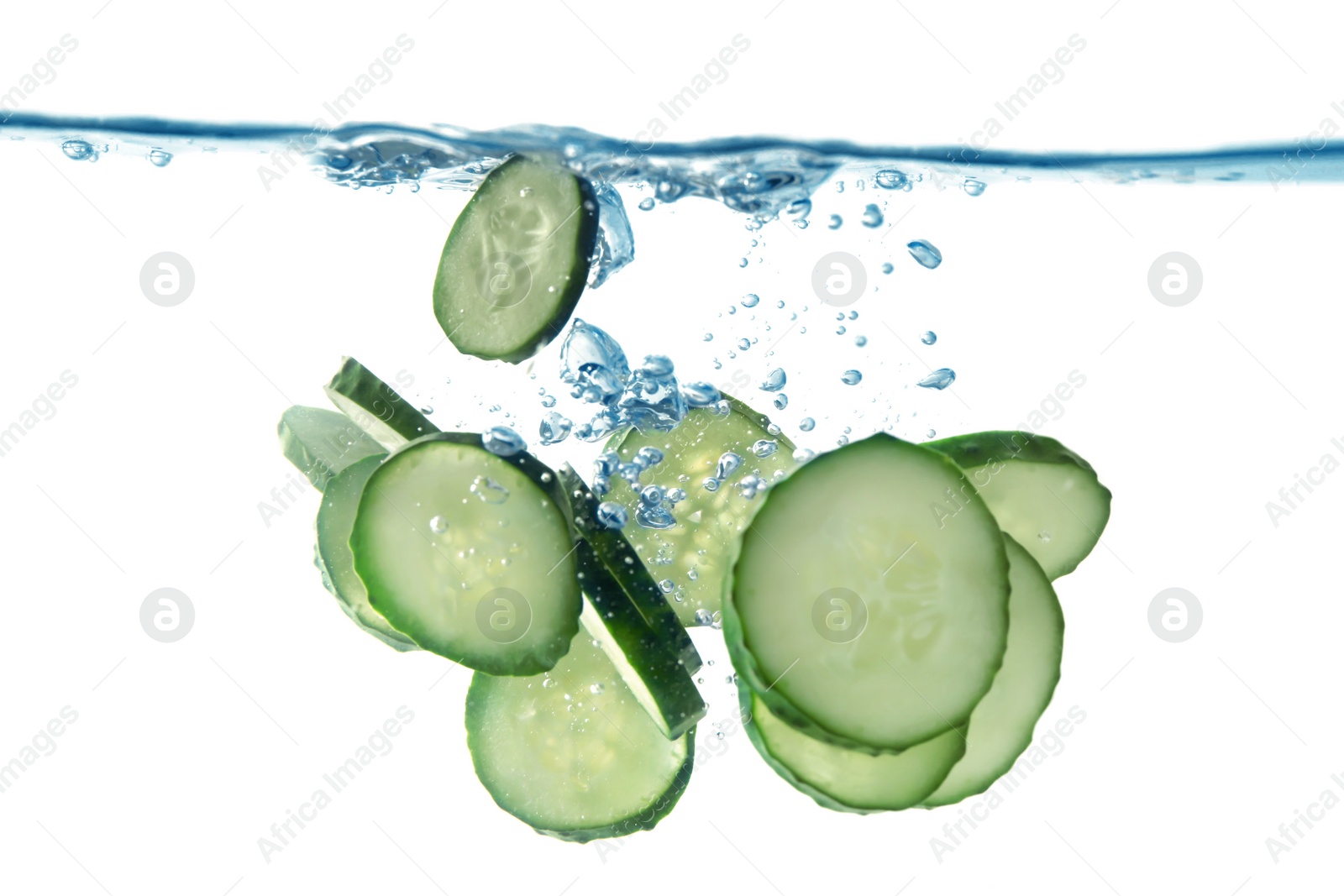 Photo of Slices of fresh cucumber falling into water on white background, closeup