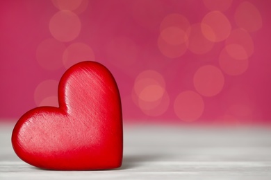 Photo of Red decorative heart on white table against pink background, space for text. Valentine's Day