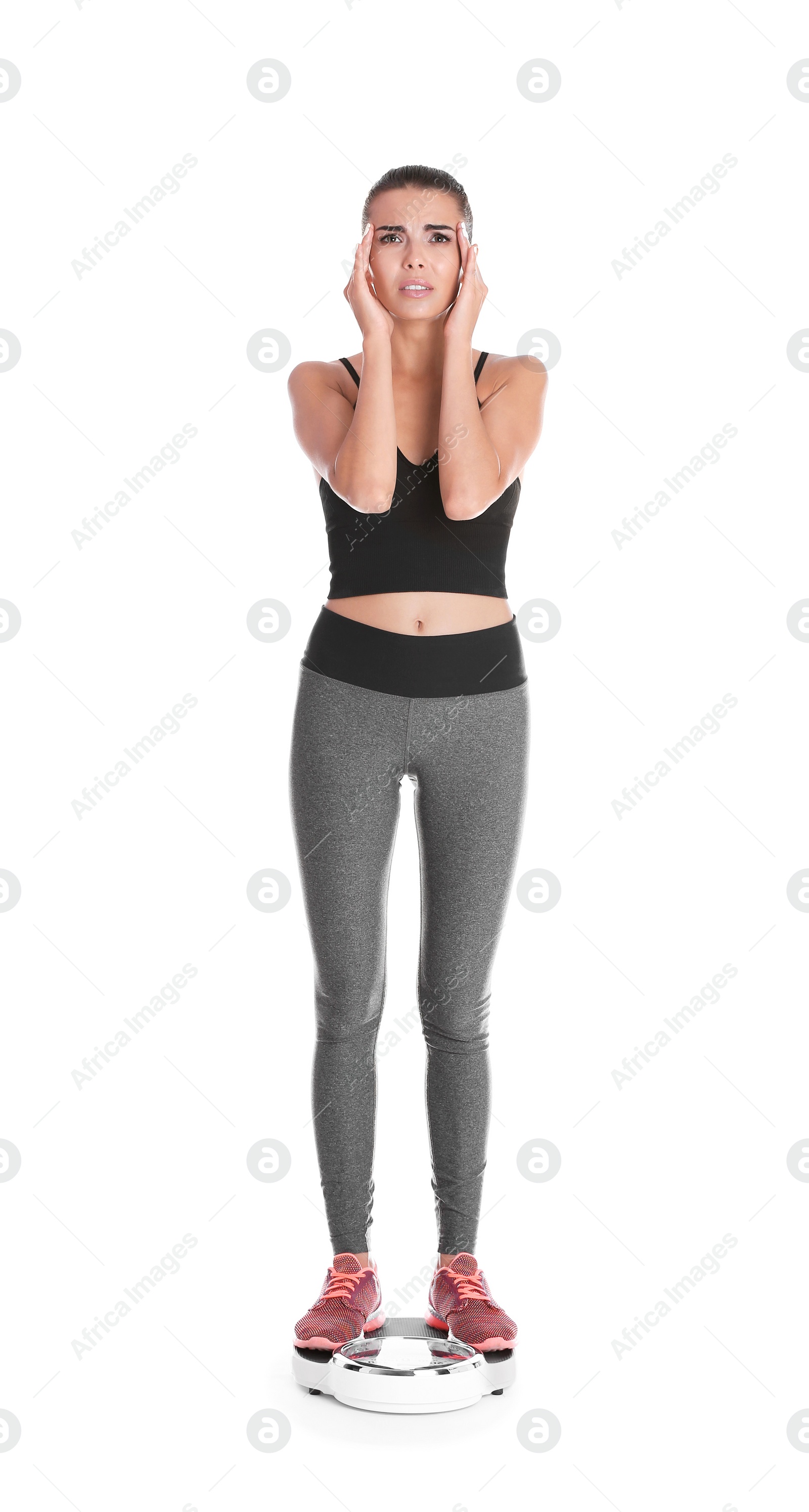 Photo of Young woman measuring her weight using scales on white background. Weight loss motivation