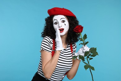 Photo of Funny mine with red rose posing on light blue background