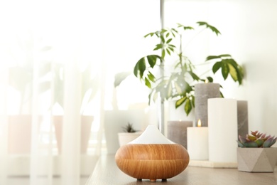 Photo of Composition with modern essential oil diffuser on wooden shelf indoors, space for text