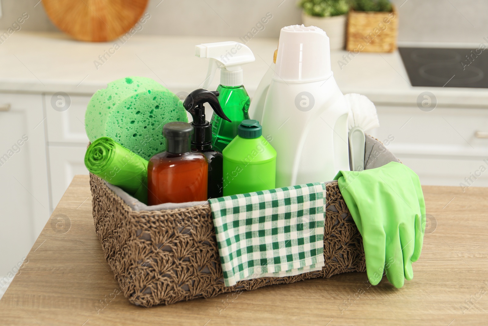 Photo of Different cleaning supplies in basket on table