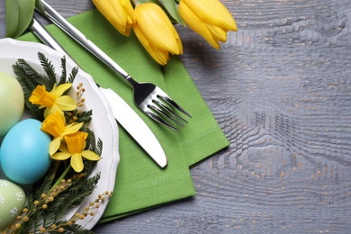 Photo of Festive Easter table setting with eggs on grey wooden background, flat lay. Space for text