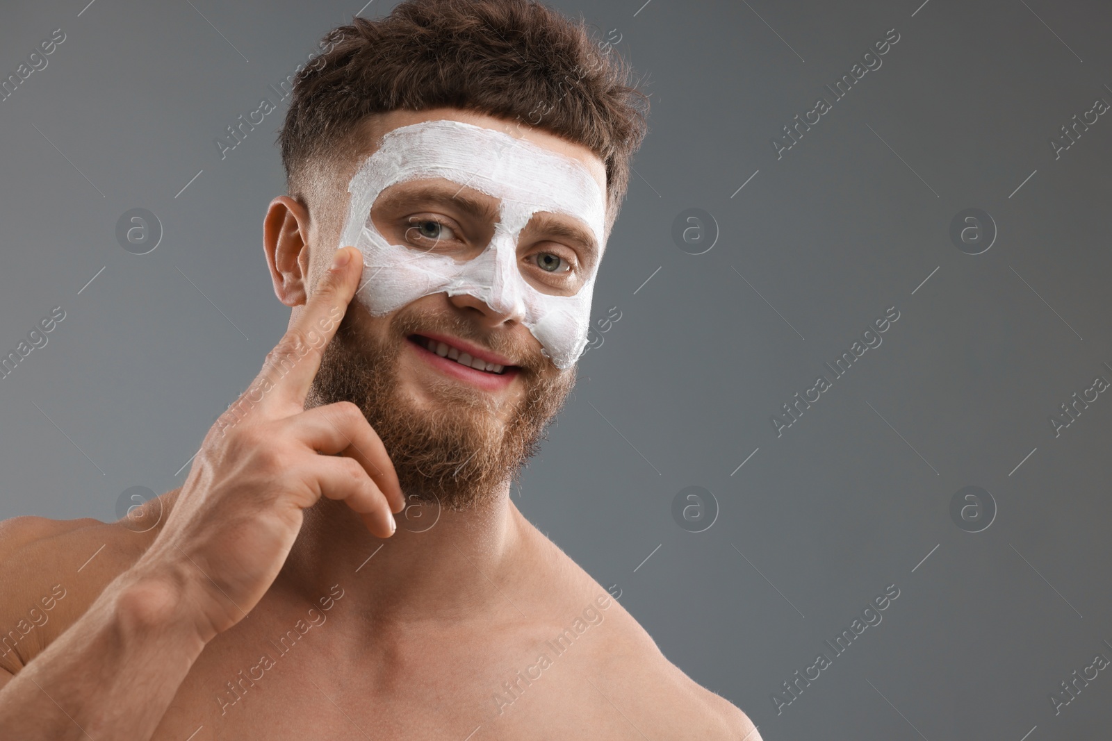 Photo of Handsome man with facial mask on his face against grey background, space for text