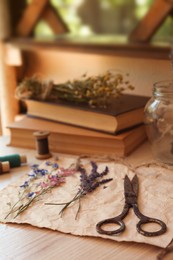 Composition with beautiful dried flowers and paper on wooden table