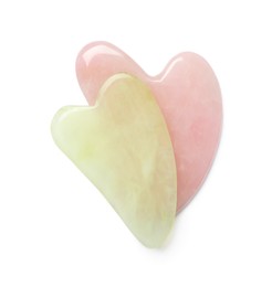 Jade and rose quartz gua sha tools on white background, top view