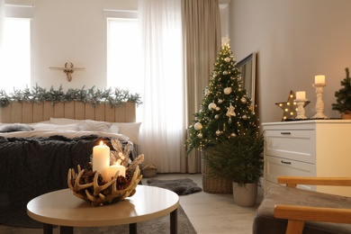 Photo of Beautiful decorated Christmas tree with fairy lights in bedroom interior