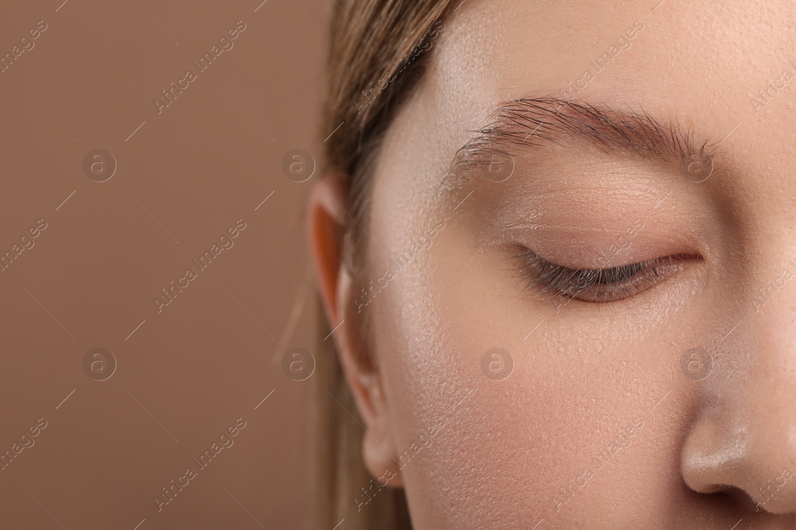 Photo of Woman with beautiful natural eyelashes on light brown background, closeup. Space for text