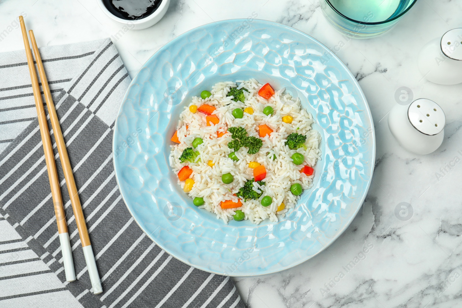 Photo of Boiled rice with vegetables served on marble table, flat lay