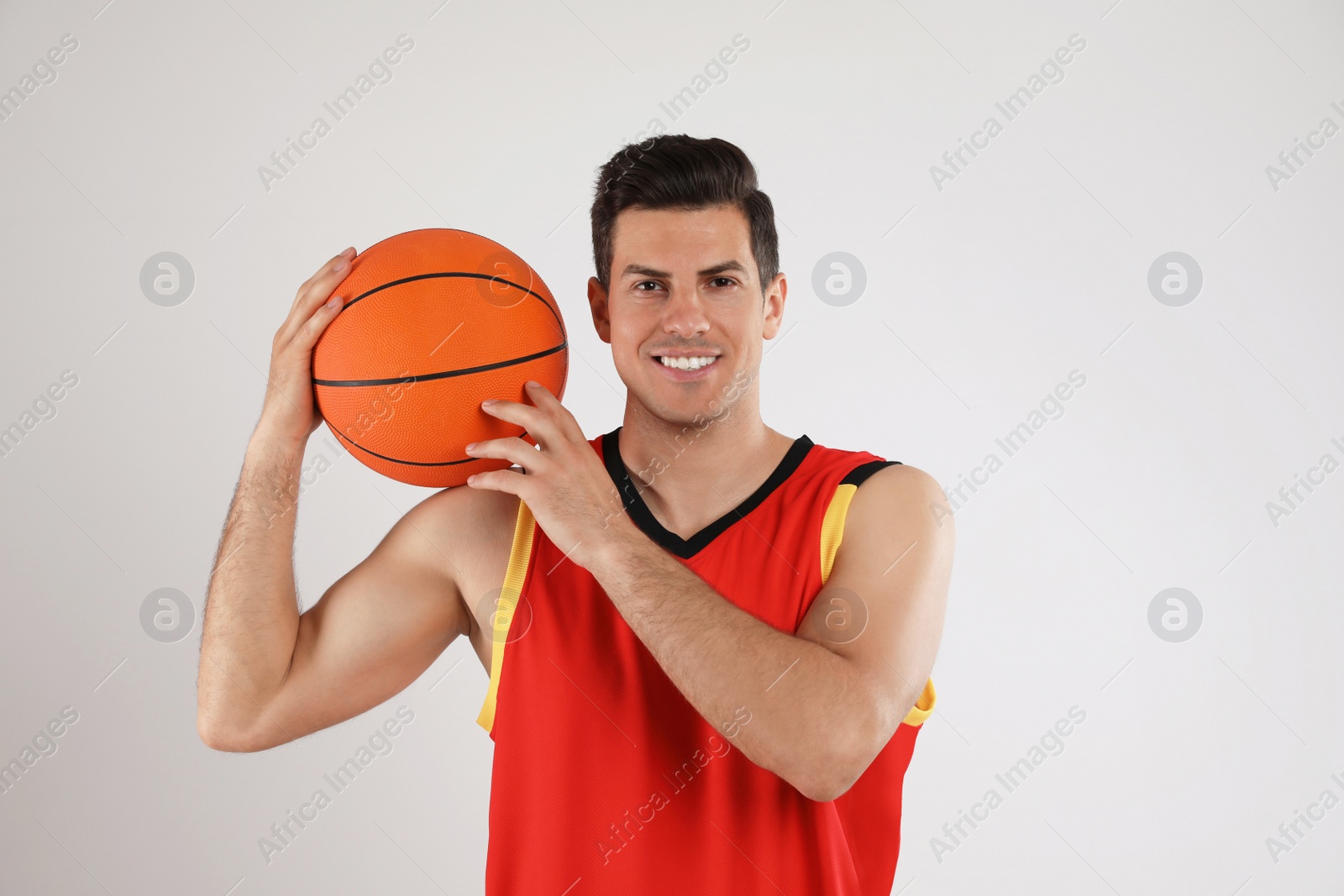 Photo of Basketball player with ball on grey background