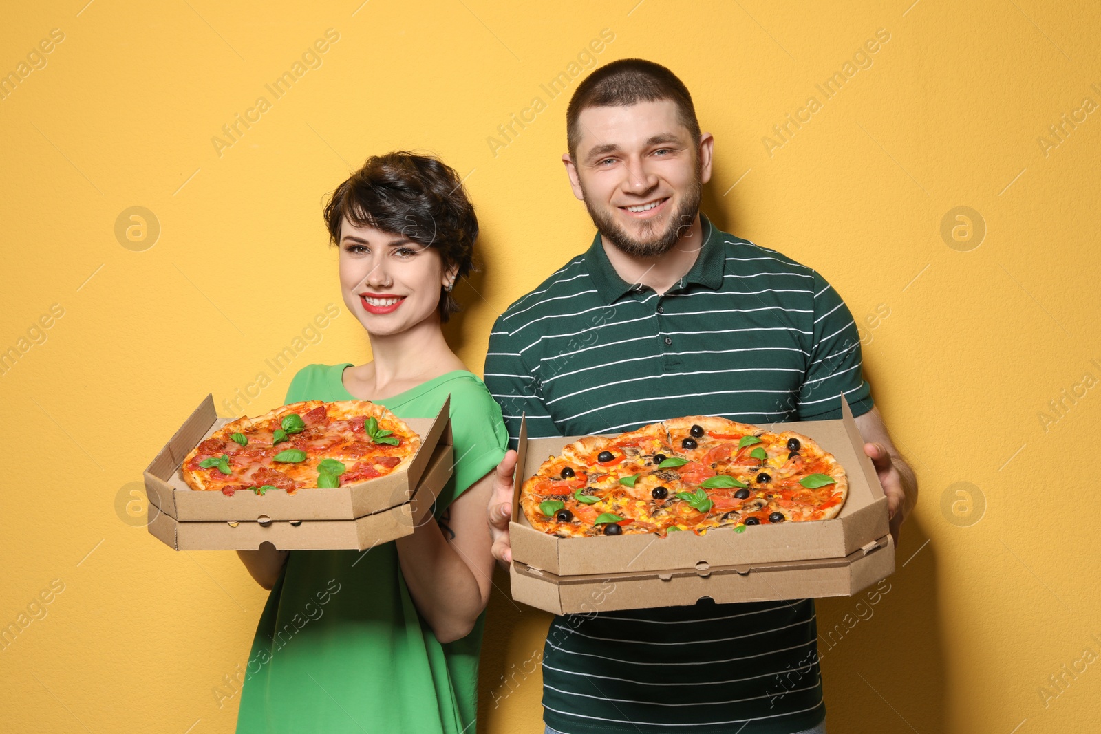 Photo of Attractive young couple with delicious pizza on color background