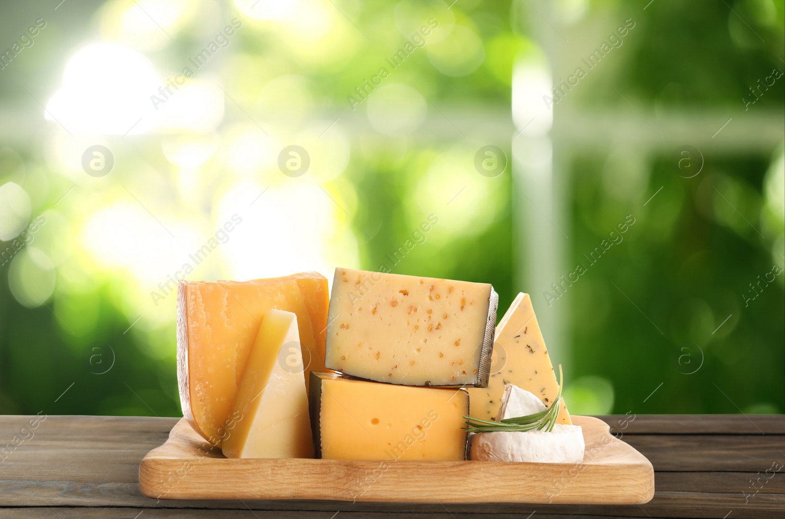 Image of Different types of delicious cheeses on wooden table outdoors. Dairy products