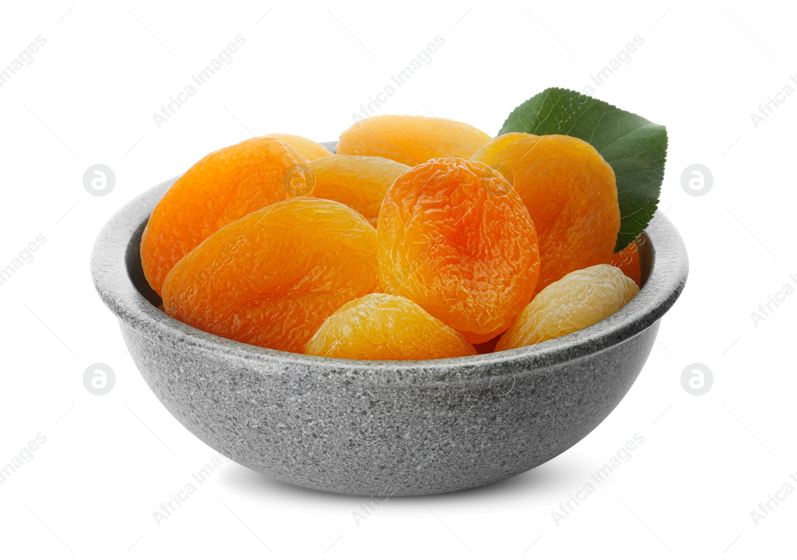 Photo of Ceramic bowl with tasty dried apricots and leaf isolated on white