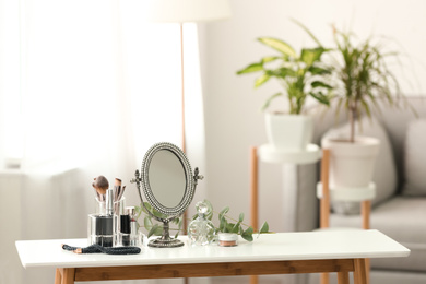 Mirror and makeup products on white table indoors. Space for text