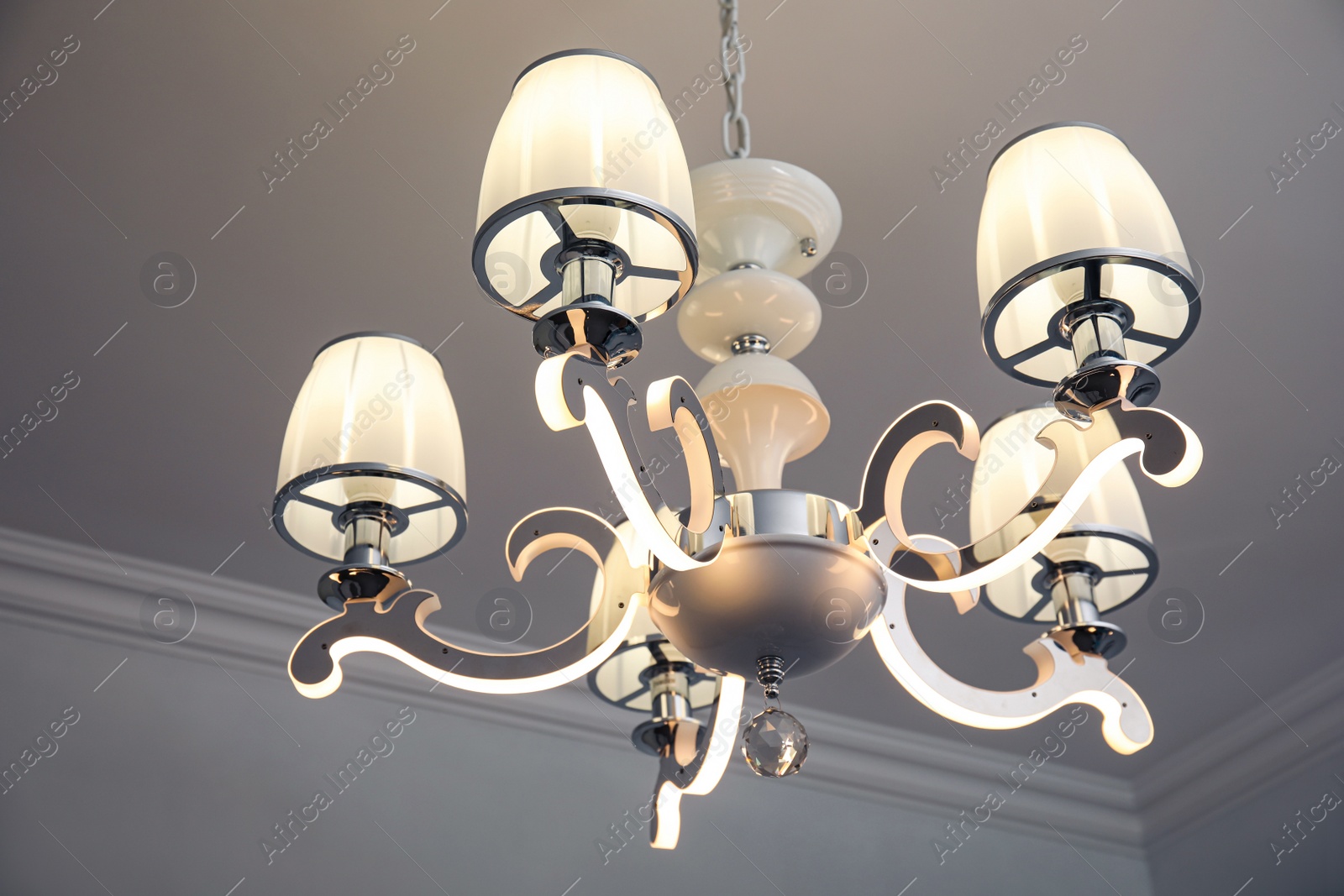 Photo of Stylish chandelier on ceiling in light room