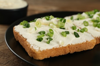 Delicious sandwiches with cream cheese and chives on table, closeup