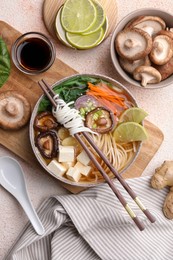 Vegetarian ramen, chopsticks and ingredients on light textured table, flat lay