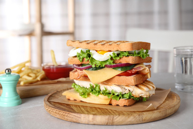 Photo of Tasty sandwich with chicken served on grey kitchen table