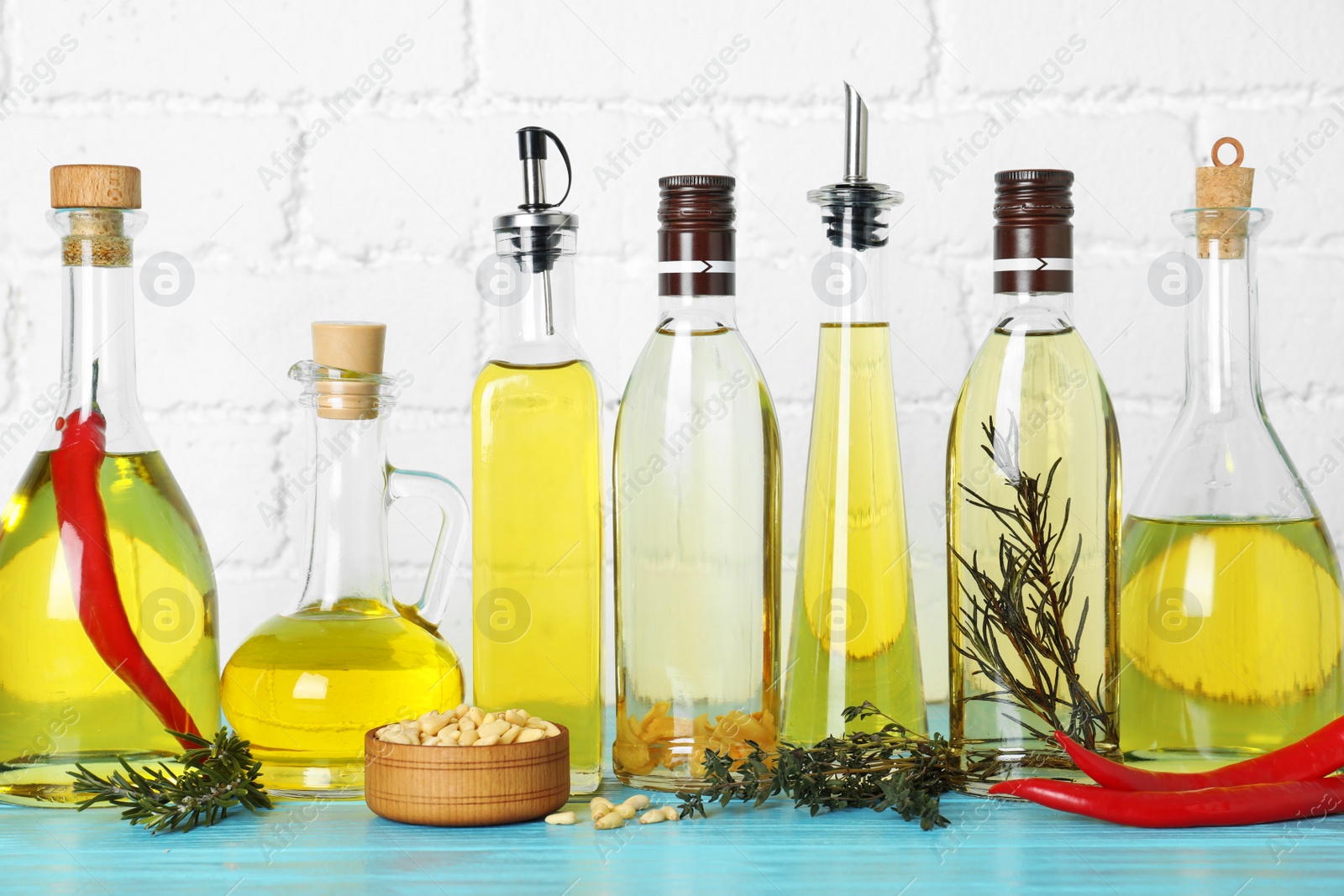 Photo of Different cooking oils on blue wooden table