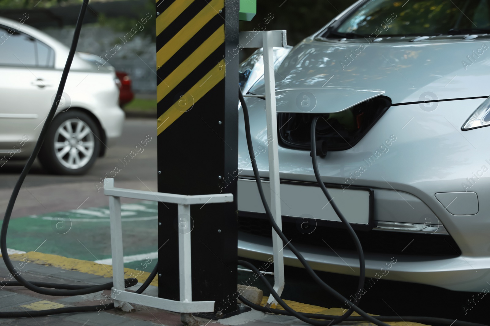 Photo of Charging modern electric car from station outdoors