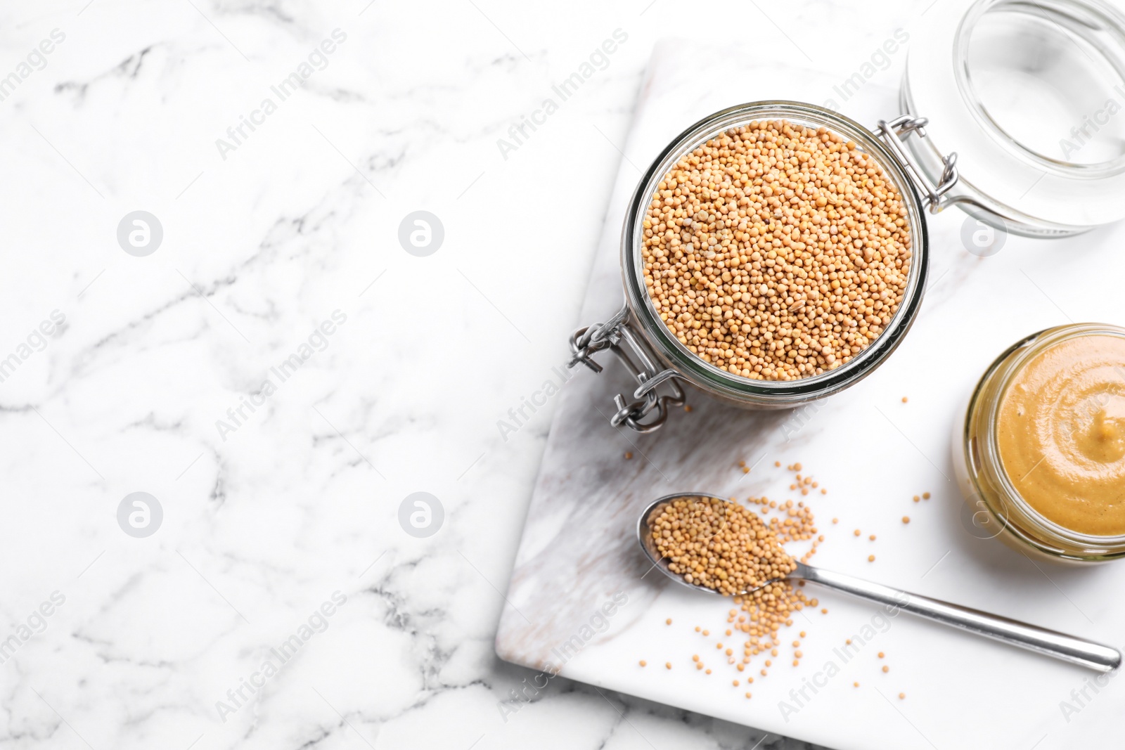 Photo of Flat lay composition with mustard seeds on white marble table, space for text