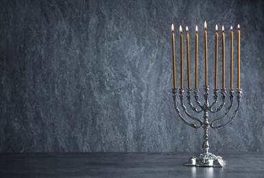 Hanukkah menorah on table against grey background