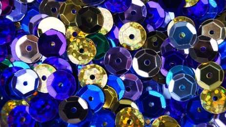 Photo of Many different colorful sequins as background, top view