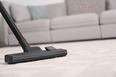 Photo of Hoovering floor with modern vacuum cleaner, closeup. Space for text