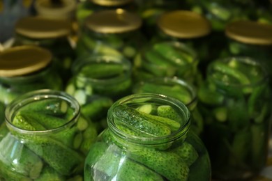 Photo of Pickling jars with fresh ripe cucumbers, closeup